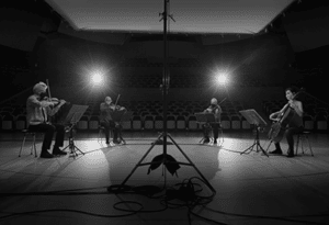 black-and-white photo of Kronos Quartet performing on stage